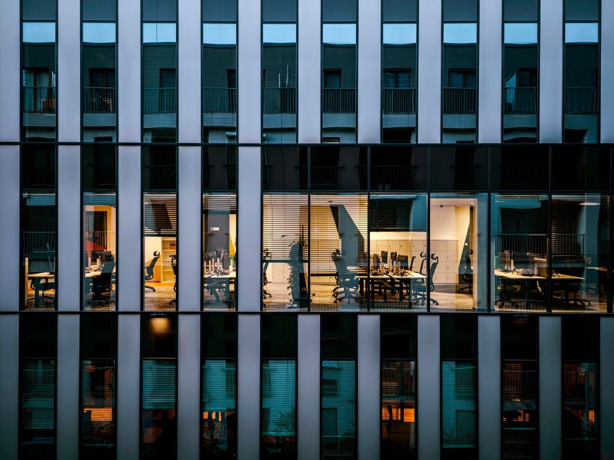 Modern corporate office building with lit workspaces