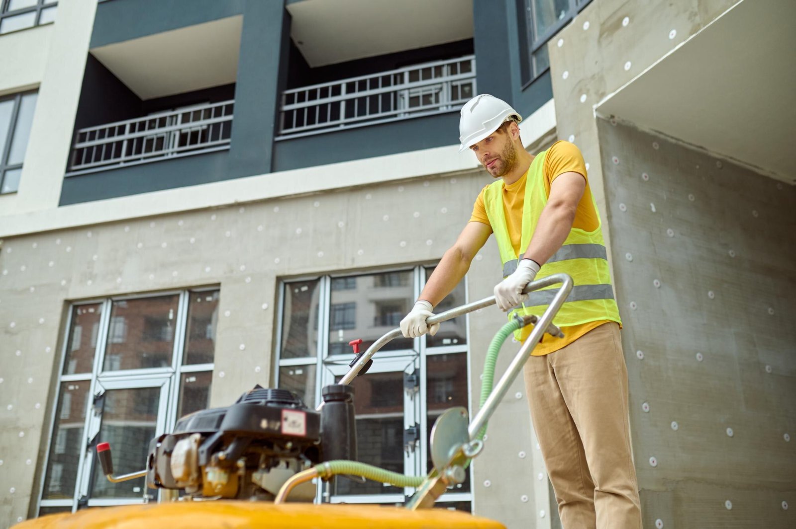Worker performing post-construction clean-up on a building site